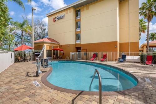 a hotel with a swimming pool in front of a building at Comfort Inn & Suites Orlando North in Sanford