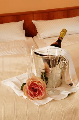 a bottle of champagne and a flower on a bed at Apfelblüte bed & breakfast 8 km vom Bodensee in Salem