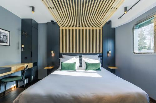 a bedroom with a large bed with a wooden ceiling at Savy Hôtel in Verdun