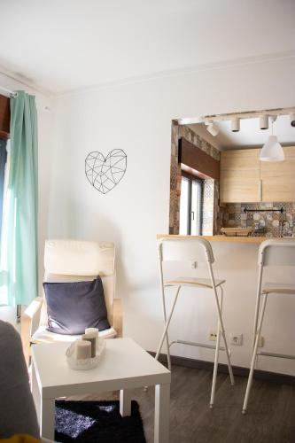 a living room with a table and chairs and a kitchen at Casa da Avó Bé in Portalegre