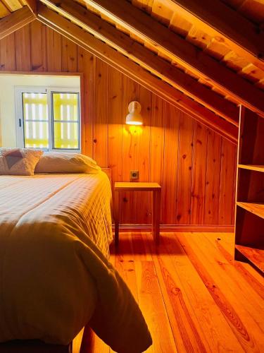 a bedroom with a bed in a wooden cabin at Casa Flor de Sal in São Mateus