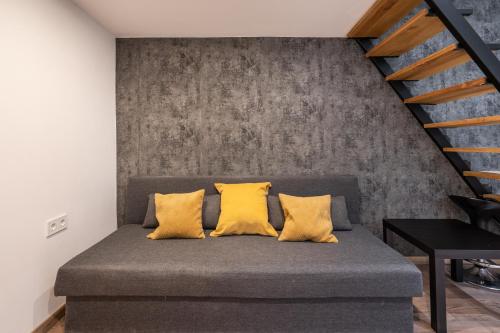 a bed with yellow pillows in a room at BpR Lore Studio au Danube in Budapest
