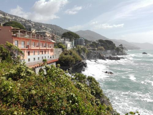 vista sull'oceano e sugli edifici su una scogliera di Un tuffo in mare a Genova
