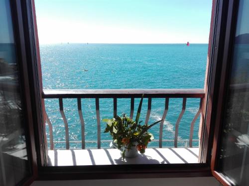 una finestra con vista sull'oceano da un balcone di Un tuffo in mare a Genova