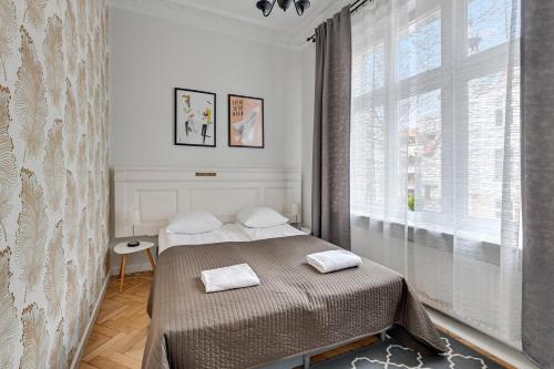 a bedroom with a bed and a large window at Atelier Apartment Centrum by Grand Apartments in Sopot