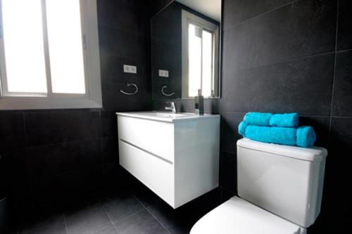 a bathroom with a sink and a toilet with a mirror at Cosmopolitan in Barcelona