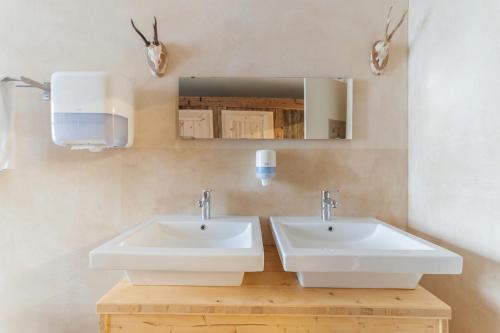 a bathroom with two sinks and a mirror at Apart Hotel Wetterhorn in Hasliberg