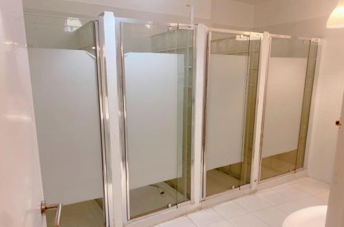 a shower with glass doors in a bathroom at Cathedral Malaga Hostel in Málaga
