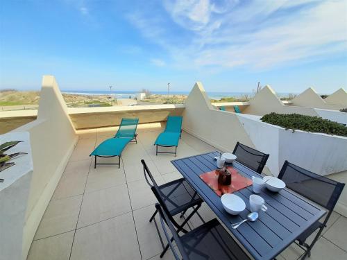 un patio avec une table et des chaises sur un balcon dans l'établissement Appartement Village Naturiste Paradoxe, au Cap d'Agde