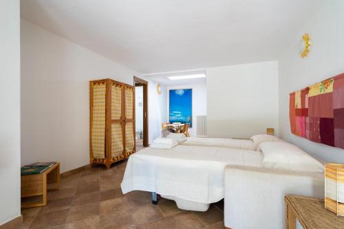 Il Giardino del Sole, Chalet Salvia في غارليندا: غرفة نوم بيضاء مع سرير وأريكة