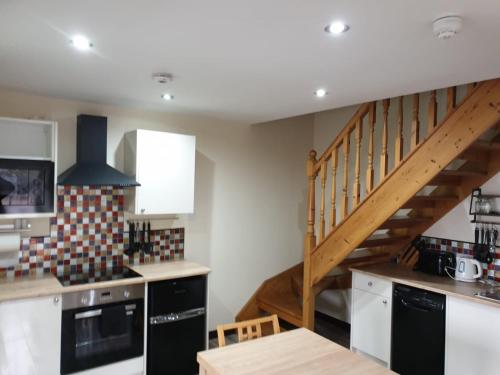 a kitchen with a staircase in the background at Culag Lochside Self Catering in Luss