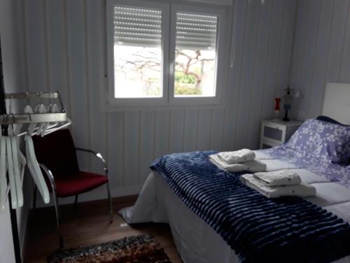 - une chambre avec un lit, une chaise et deux fenêtres dans l'établissement One bedroom house with enclosed garden and wifi at Parada, à Parada