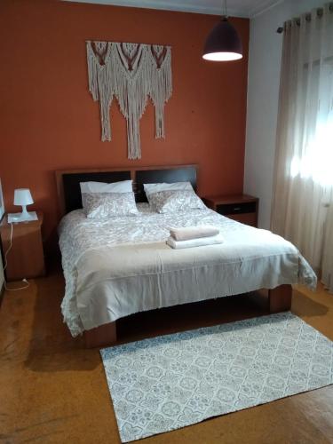 um quarto com uma cama com um edredão branco em Your HOME ECO & NATUR em Carvide