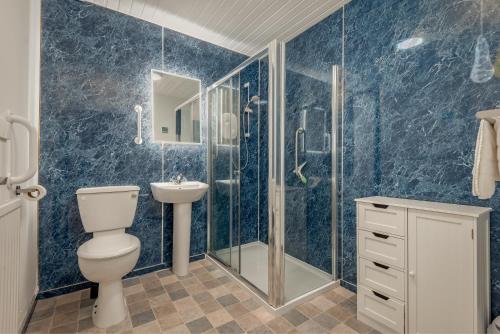a bathroom with a toilet and a shower and a sink at The Cross Keys Market Street Apartment - Sleeps 6 in St Andrews