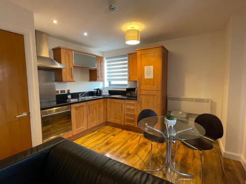 a kitchen with a glass table and chairs in it at Quality City Leicester in Leicester