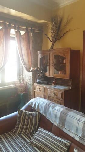 a bedroom with a wooden cabinet and a window at Casa na Serra da Estrela in Melo