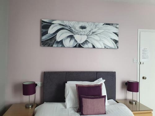 a bedroom with a bed with a flower painting on the wall at Grosvenor House Hotel in Torquay