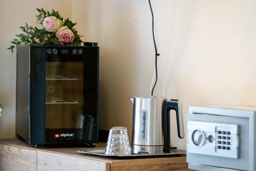 a microwave sitting on a counter next to a coffee maker at Hotel Zur Mühle in Kappeln