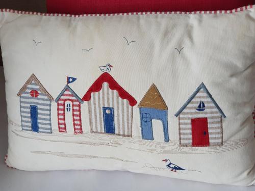 a pillow with a painting of beach houses and a bird at Grosvenor House Hotel in Torquay