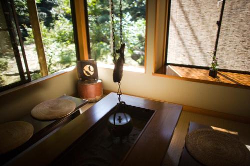 a living room with a table and two windows at Motoyu Ishiya in Kanazawa