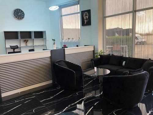 a waiting room with black chairs and a table at Hotel Daly in Ploieşti