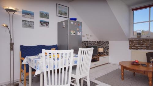 a kitchen with a table and chairs and a refrigerator at Ferienwohnung Kleine Auszeit in Ostseebad Sellin