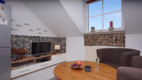 a living room with a table and a television at Ferienwohnung Kleine Auszeit in Ostseebad Sellin