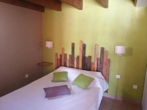 une chambre avec un lit avec deux oreillers dessus dans l'établissement Gîtes de l'Esquirou, à Lagorce