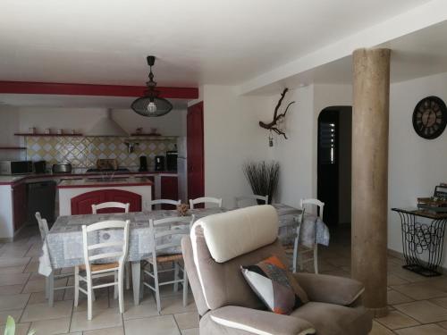 ein Wohnzimmer und eine Küche mit einem Tisch und Stühlen in der Unterkunft Gîtes de l'Esquirou in Lagorce