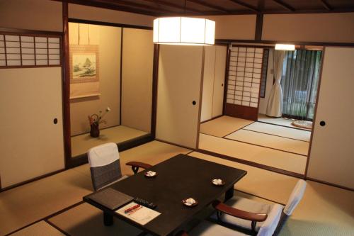 a dining room with a table and chairs in a room at Motoyu Ishiya in Kanazawa