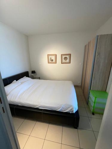 ニーウポールトにあるAppartement Nieuwpoortの小さなベッドルーム(ベッド1台、緑のスツール付)