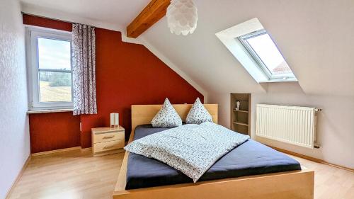 a bedroom with a bed and two windows at Ferienwohnung Schwalbennest am Igelsbachsee in Absberg