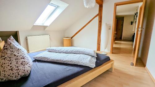 um quarto com uma cama com lençóis azuis e uma janela em Ferienwohnung Schwalbennest am Igelsbachsee em Absberg