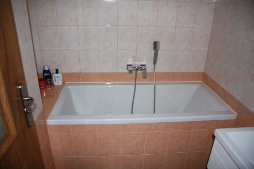 a bath tub in a bathroom with a phone at Chata Holiday in Bítov