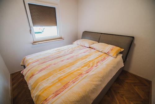 a bed in a small room with a window at Holiday Home Liberg with Hot tub and Sauna in Brežice