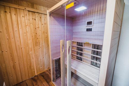 a walk in shower in a room with wooden walls at Holiday Home Liberg with Hot tub and Sauna in Brežice