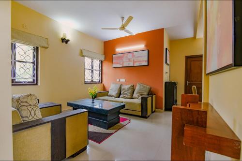 a living room with a couch and a table at FabHotel New kolkata Residency Inn - Nr Axis Mall in Kolkata
