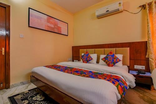 a bedroom with a large bed and a tv on the wall at FabHotel New kolkata Residency Inn - Nr Axis Mall in Kolkata