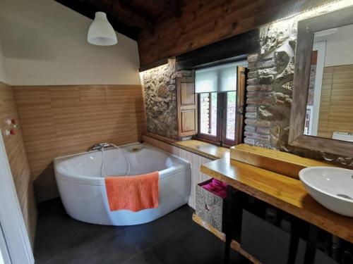 a bathroom with a bath tub and a sink at La Cabaña de Naia in La Revilla