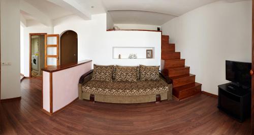 a living room with a bed and a staircase at Babylon Apartment on Bukovinskaya Street in Rivne