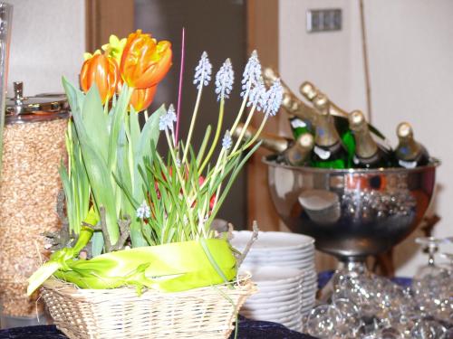 a basket of flowers and wine bottles on a table at Hotel - Restaurant - Metzgerei Sonne in Loffenau