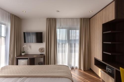 Schlafzimmer mit einem Bett, einem TV und einem Fenster in der Unterkunft Villa Fortis B&B in Trogir
