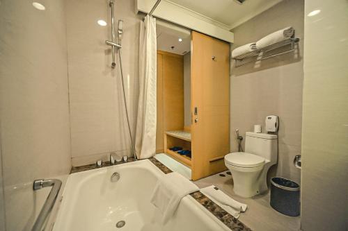 bagno con vasca e servizi igienici di All Sedayu Hotel Kelapa Gading a Giacarta