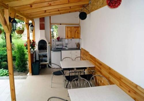 Il comprend une cuisine et un coin repas avec des tables et des chaises. dans l'établissement Къща за гости Хриси, à Velingrad