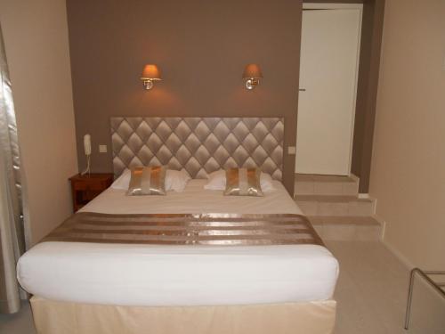 a bedroom with a large bed with two shoes on it at Hôtel Restaurant Plaisance-Piscine couverte et chauffée- Proche Sarlat- in Vitrac