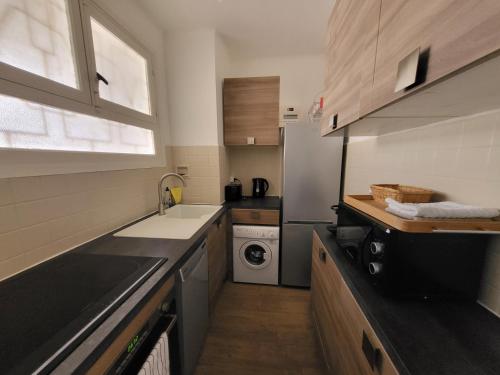 Una pequeña cocina con fregadero y lavadora. en LE COLOMBIER STUDIO, en Antibes