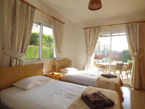 a hotel room with two beds and a window at Villa Isabella: Coral Bay Beach, Seaview in Peyia