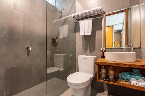 a bathroom with a toilet and a sink and a shower at Ecozy Dijiwa Canggu in Canggu