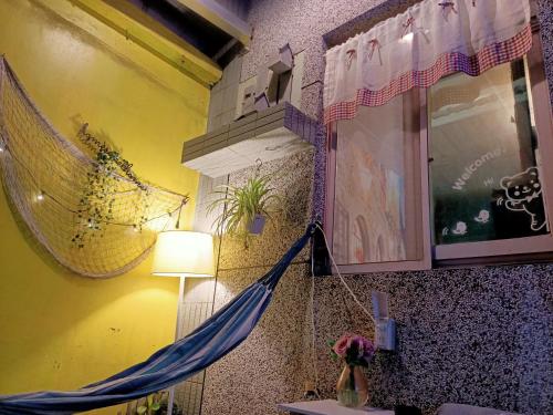 a room with a hammock hanging from a wall at 七十腳落背包客棧 in Green Island