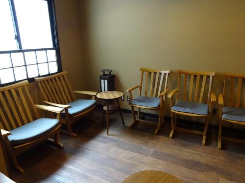 a waiting room with chairs and a table and a window at Dormy Inn Hakata Gion in Fukuoka